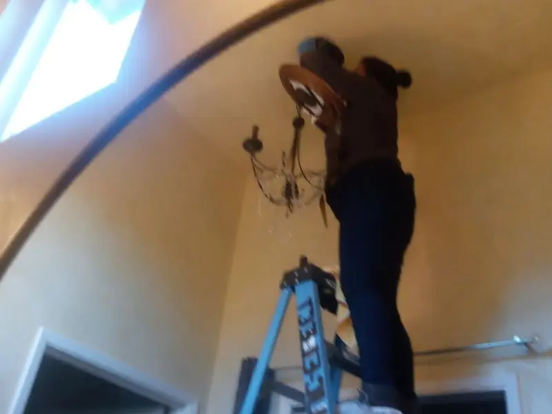 Electrician installing a chandelier in a Mount Pleasant residence
